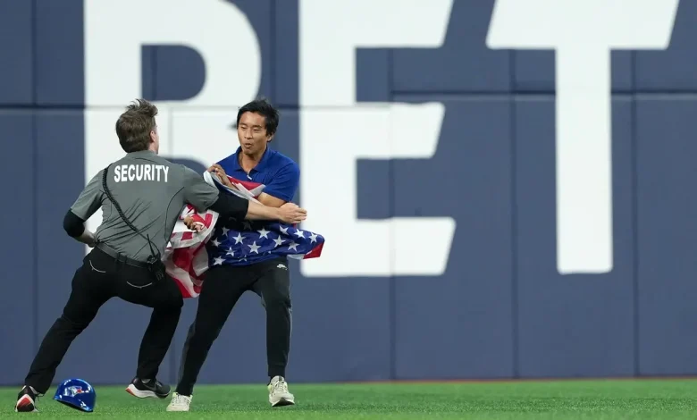 Fan with American flag runs onto field in Toronto during Game 6 of World Series
