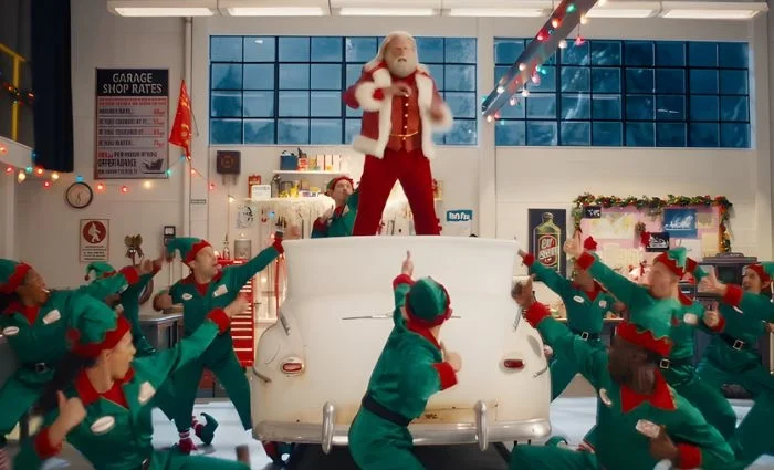 John Travolta’s Santa channels Danny Zuko for Capital One