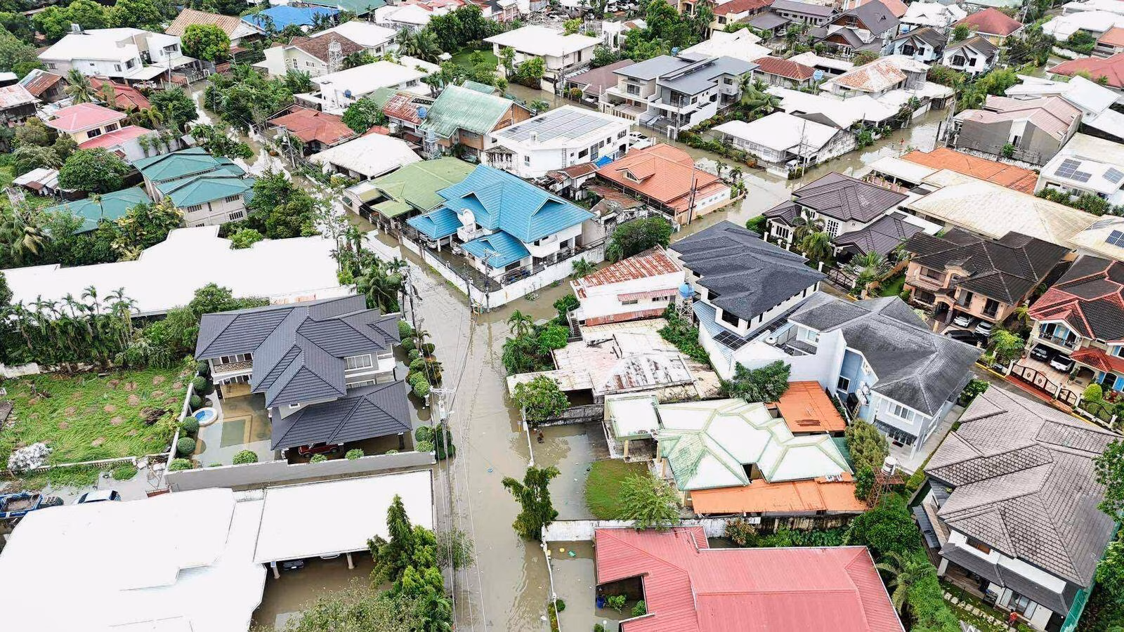 Typhoon leaves at least 2 dead, traps people on roofs and submerges cars in central Philippines