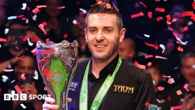 Selby holds off spirited Trump to win third UK title